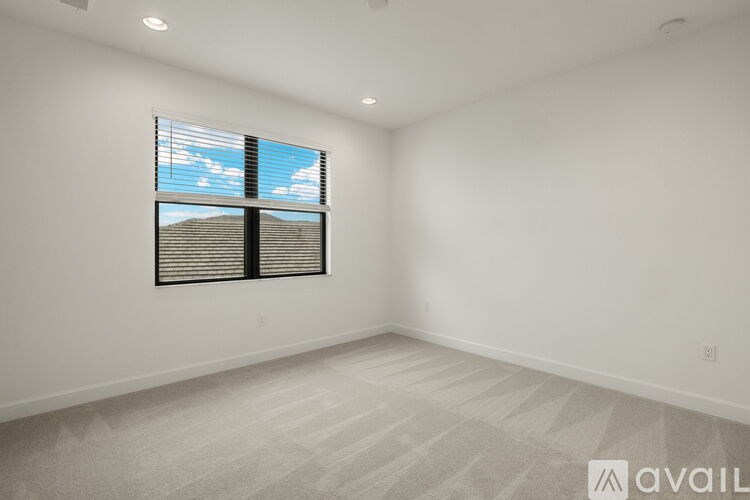 A room with a window and a carpeted floor.