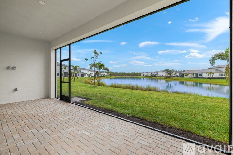 A modern house with a view of a lake and houses in the distance.