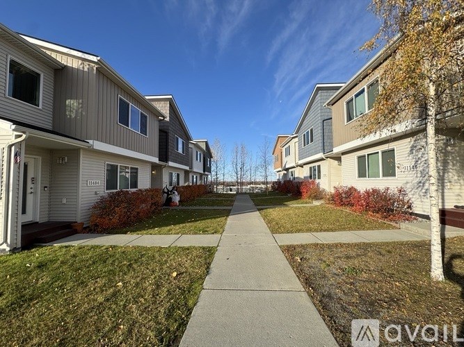 A row of houses with a sidewalk in between.