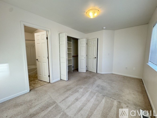 A carpeted room with a doorway open to another room.