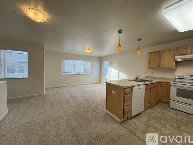 A kitchen with white appliances and wooden cabinets.