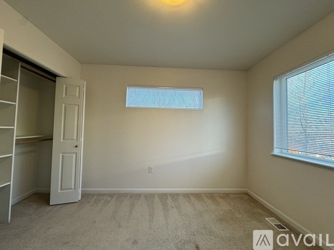 A room with a window and a door is available for rent.