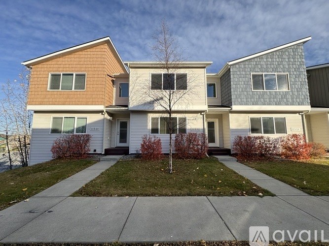 A house with a front yard and a tree in the front.