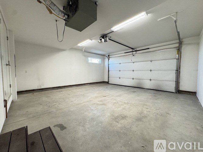 A large, empty garage with a white door and a window.