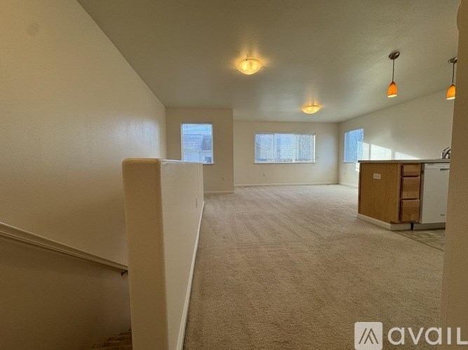 A spacious room with a carpeted floor and a window.
