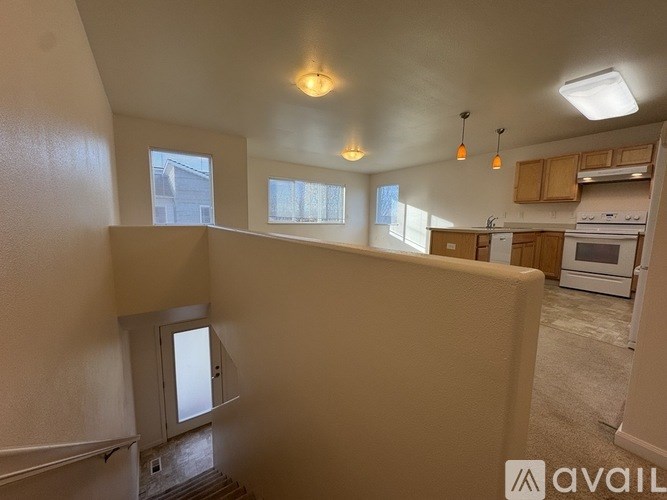 A kitchen area with a refrigerator, oven, and a window.