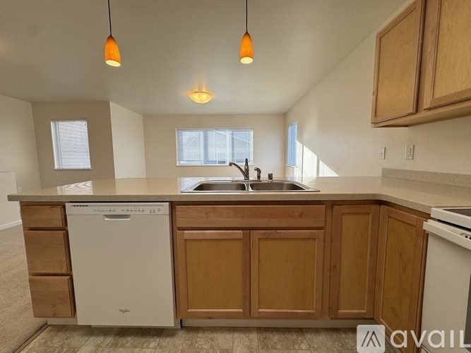 A kitchen with wooden cabinets and a white dishwasher.