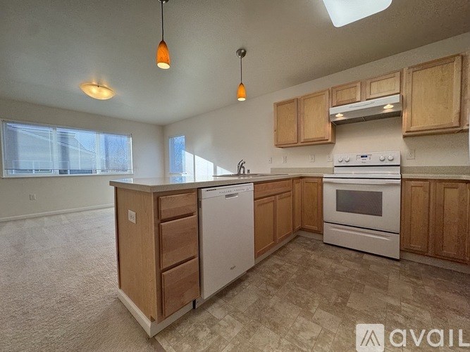 A kitchen with wooden cabinets and a white dishwasher.