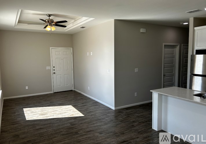 A room with a ceiling fan and a rug on the floor.