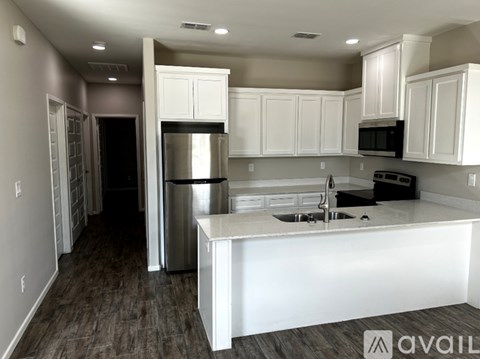 A kitchen with white cabinets and a large island.