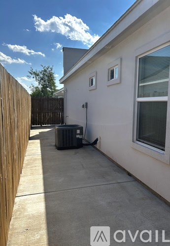 A white house with a window and a door with a black gate and a window.