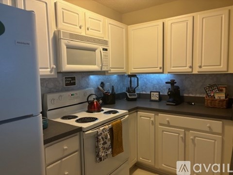 A kitchen with white cabinets and appliances.