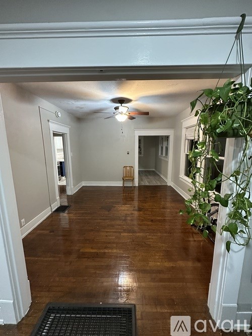 A hallway with wood floors and a ceiling fan.