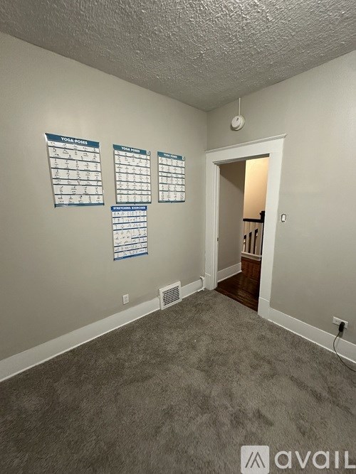 A room with a carpeted floor and three signs on the wall.