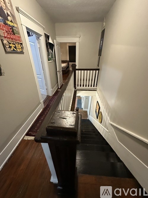 A long hallway with a bench and a framed picture on the wall.