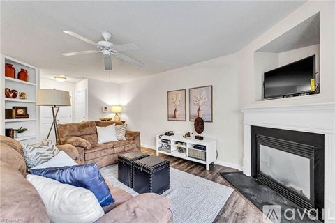 A living room with a fireplace and a television on the wall.