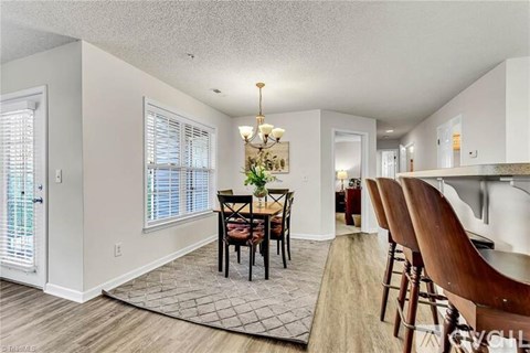 A dining room with a table set for four.