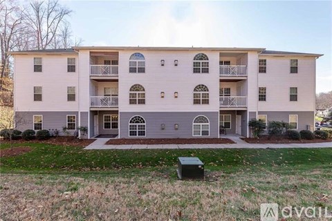 A two-story apartment building with a balcony on the second floor.