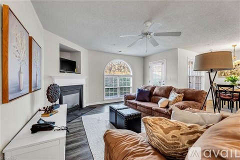 A living room with a fireplace and a brown couch.