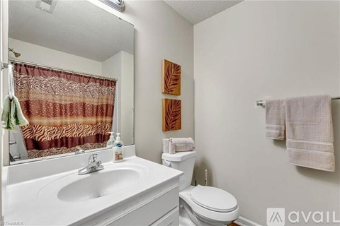 A bathroom with a toilet, sink, and towel rack.
