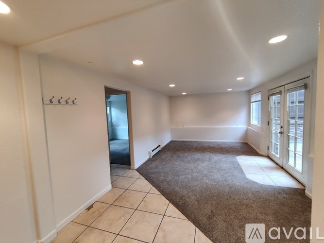 A room with a carpeted floor and a door leading to a balcony.