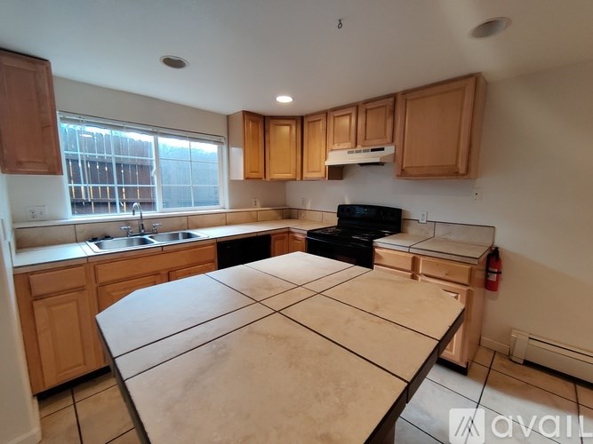 A kitchen with wooden cabinets and a black stove top oven.