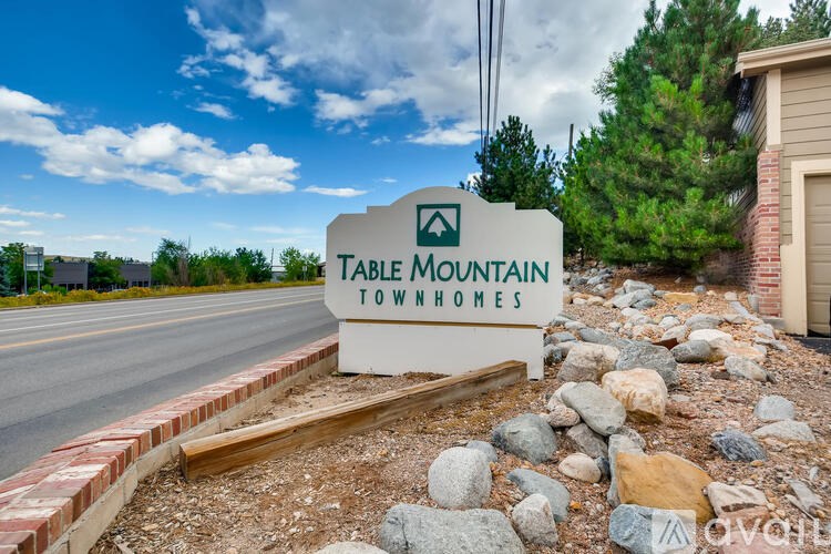 A sign for Table Mountain Townhomes sits in front of a house.