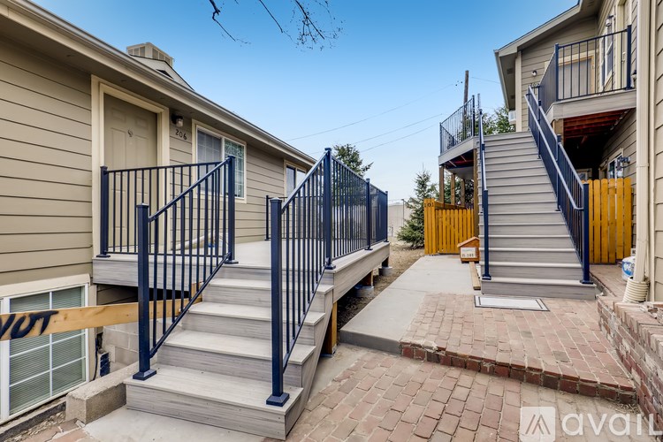 A set of stairs with a metal railing leads up to a door.