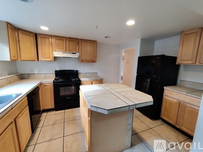 A kitchen with black appliances and wooden cabinets.