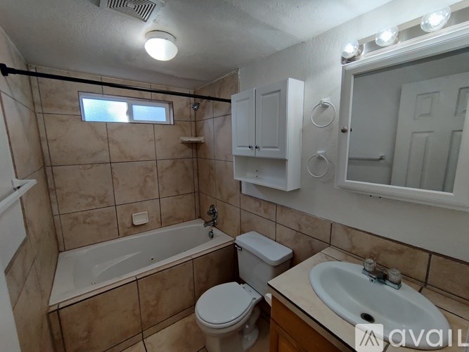 A bathroom with a tub, toilet, and sink.
