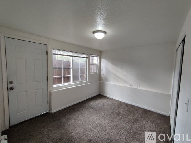 A room with a carpeted floor and a door leading to a balcony.