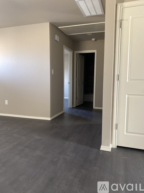 A room with a white door and a grey floor.