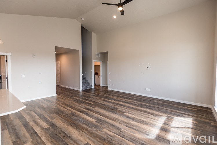 A room with wooden flooring and a ceiling fan.