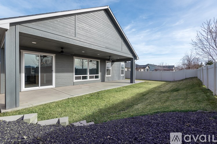 A modern house with a grey exterior and a large front yard.
