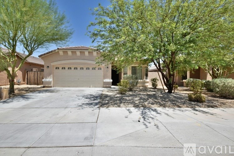 A house with a garage and a tree in front.