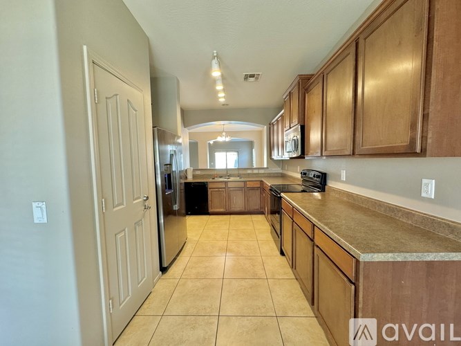 A kitchen with wooden cabinets and a tiled floor.