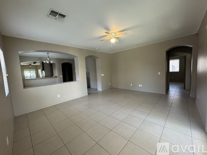 A spacious room with a ceiling fan and tiled flooring.
