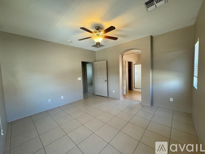 A room with a ceiling fan and tiled floor.