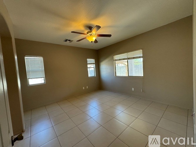 A room with a ceiling fan and tile flooring.