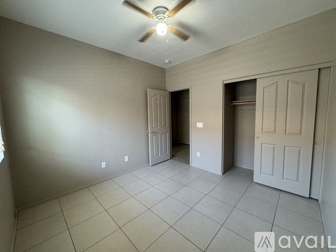 A room with a ceiling fan and two doors.