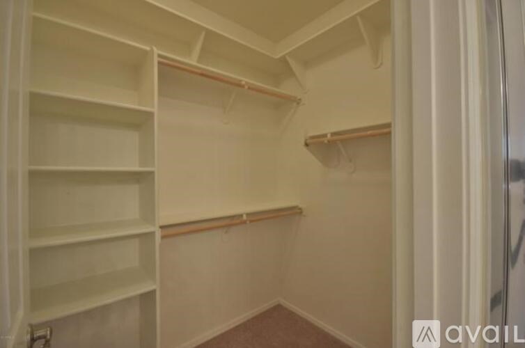 A white closet with shelves and a door on the right.