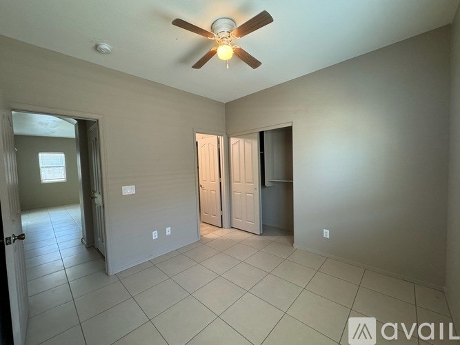 A room with a ceiling fan and tile flooring.