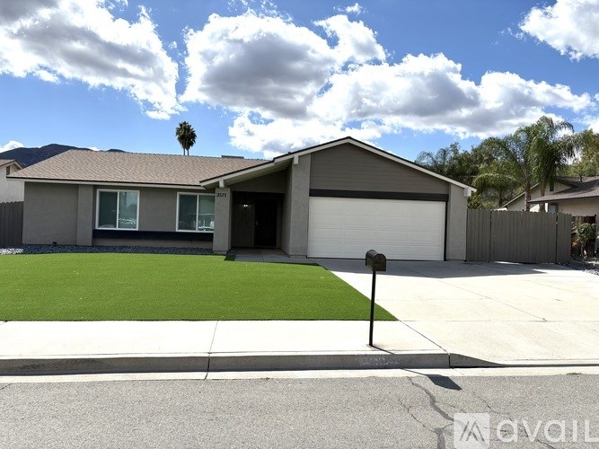 A house with a garage and a driveway in front of it.