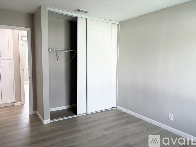 A room with a white door and a grey wall.