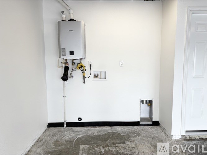 A tankless water heater is installed on the wall next to a door.