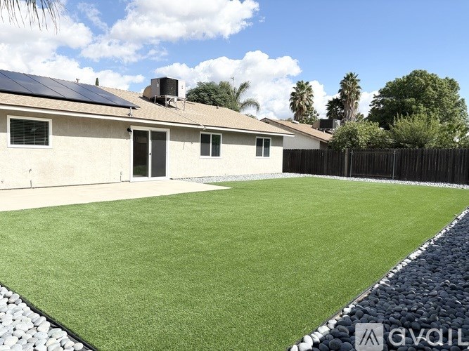 A house with a green lawn in front of it.