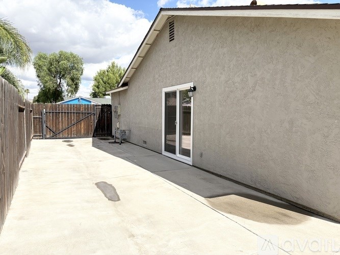 A house with a white wall and a sliding glass door.