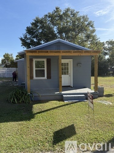 A small house with a porch is for sale.