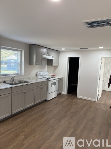 A kitchen with wooden floors and a white stove top oven.