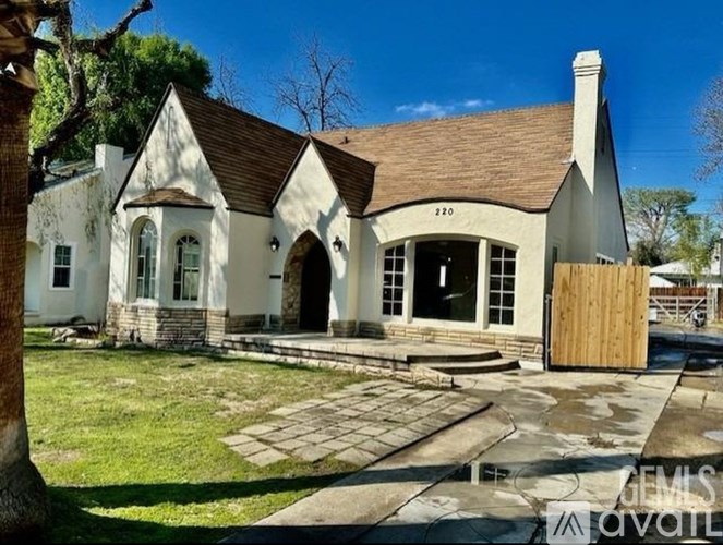 A white house with a brown roof and a wooden door.